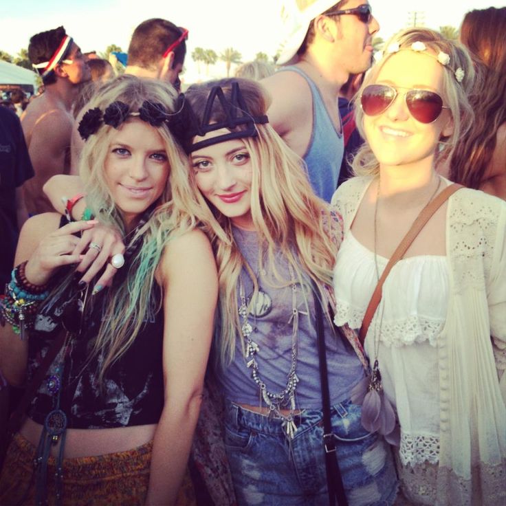 two women standing next to each other at a music festival