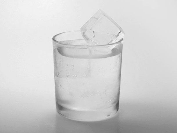 a glass filled with water and ice cubes