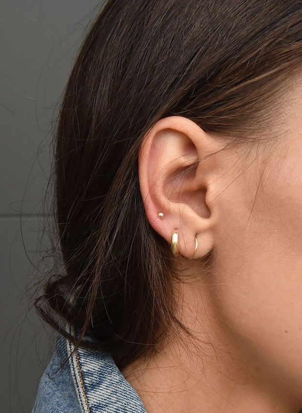 a close up of a person's ear with an earring in the middle