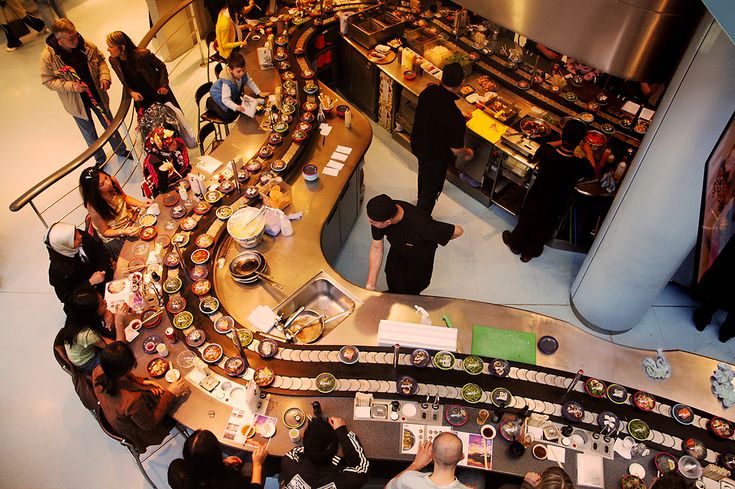 an overhead view of people standing in line at a food court, looking down on the counter