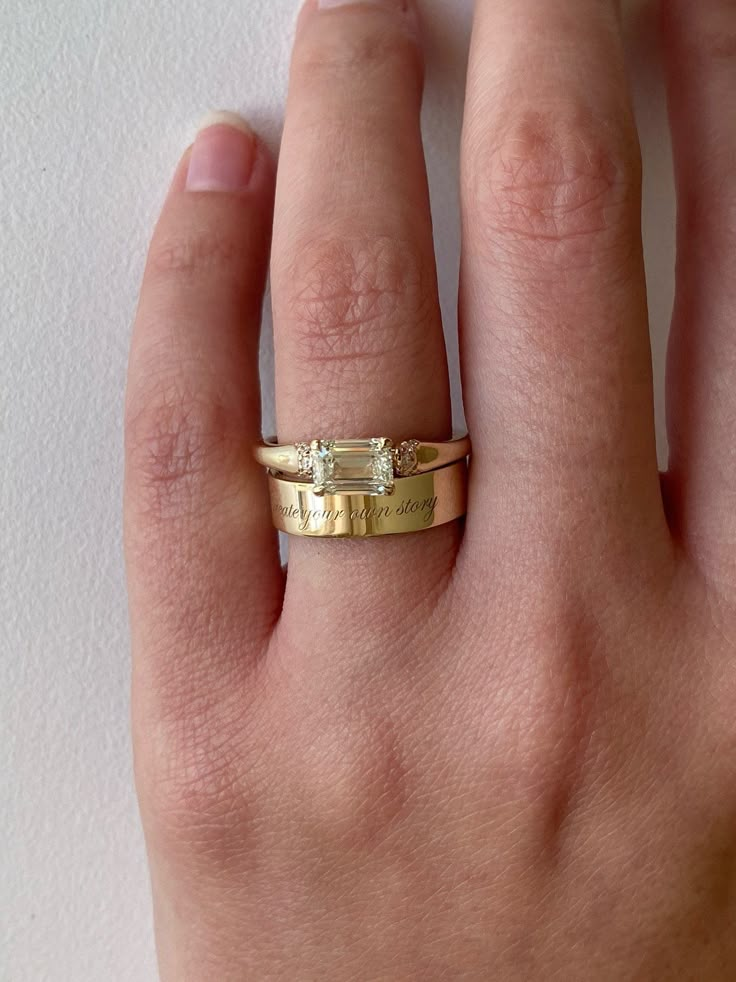 a person's hand with a gold ring on it