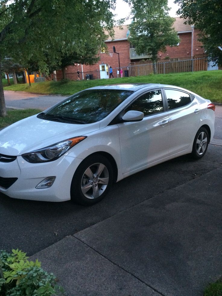 a white car is parked on the street