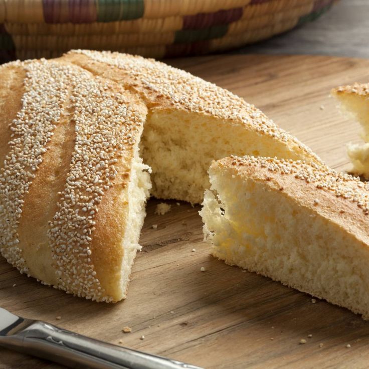 a sliced loaf of bread sitting on top of a wooden cutting board next to a knife