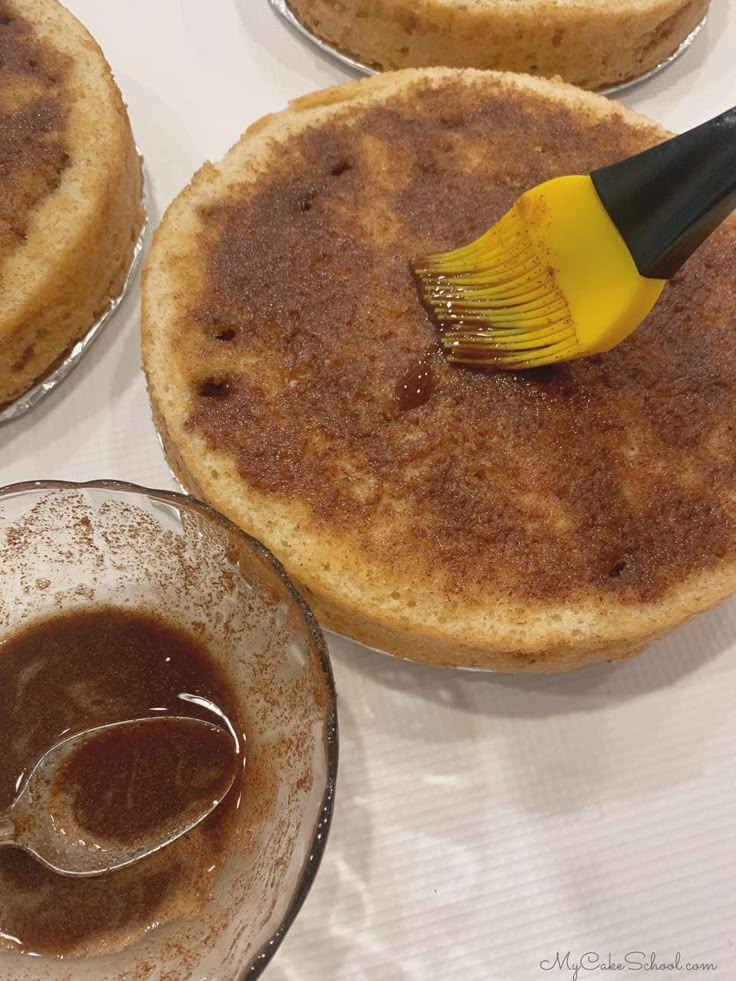 three desserts on a table with a yellow spatula in the middle and chocolate pudding below