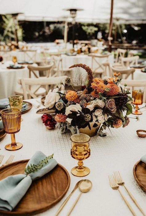 the table is set with plates, silverware and flowers