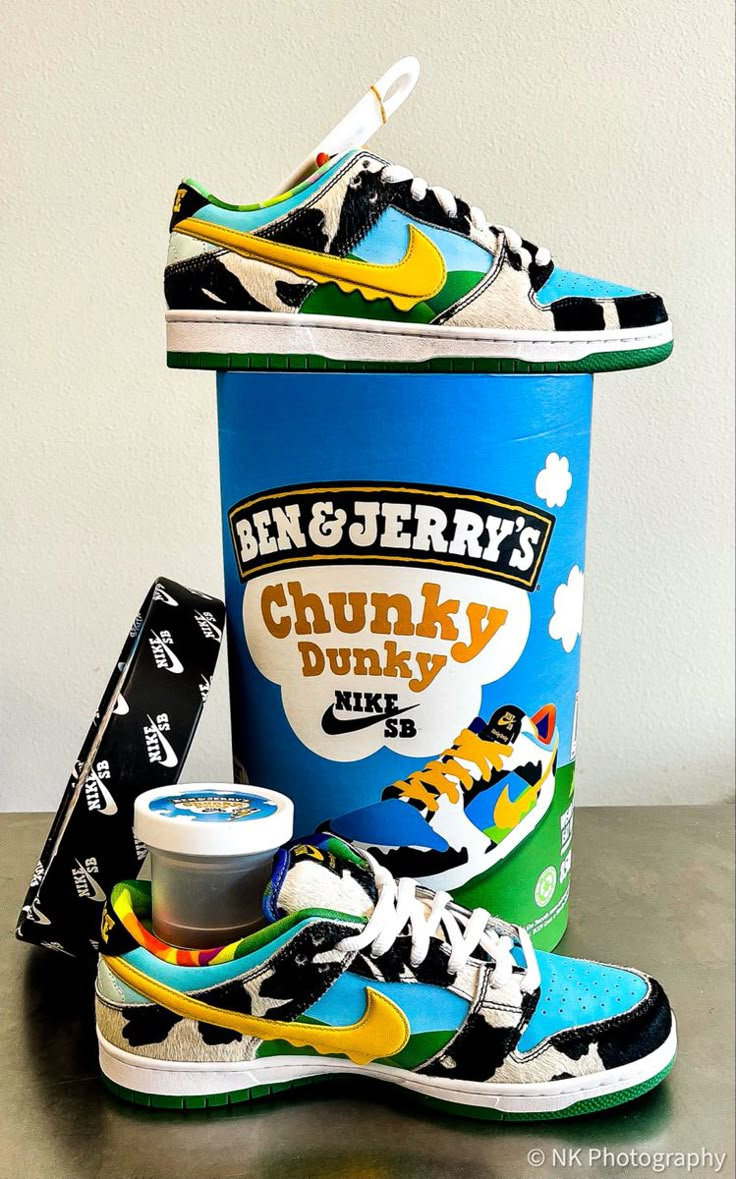 The summer collab between Nike SB and Ben & Jerry’s riffs off the Vermontian ice cream company’s delightful pint packaging. The outsole mimics the green hillside seen on the container, where cows dance in the foreground; the shoe’s leather overlays feature a hairy cow faux-print. Puffy clouds form on the heel behind a Nike wordmark in Ben & Jerry’s font. There’s tie-dye on the lining and sockliner. Finishing off the look is a drippy swoosh in the B&J’s gold. Ben And Jerrys Shoes, Chunky Dunky Nike Sb, Chunky Dunk, Ice Cream Shoes, S Font, Chunky Dunky, Nike Sb Shoes, Rick Owens Shoes, Puffy Clouds