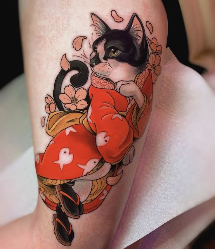 a woman's leg with a cat and heart tattoo on her thigh, while she is wearing a red dress