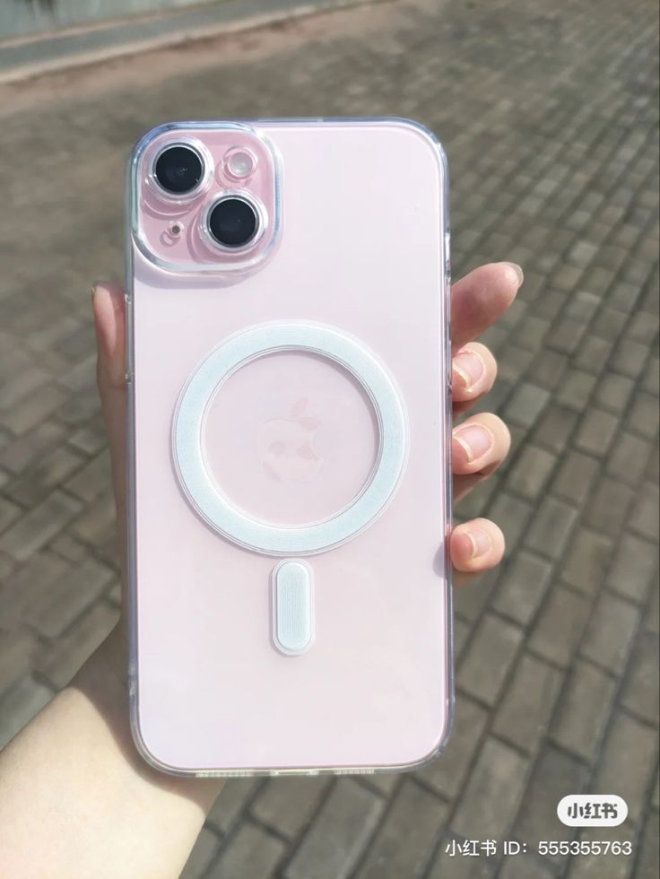 a person holding up a pink phone case with an iphone camera attached to the back