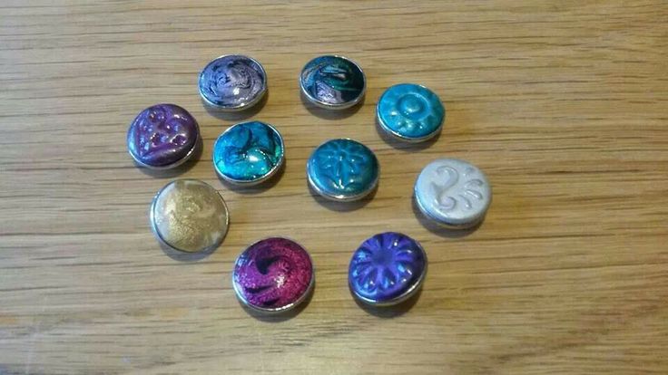 six different colored buttons sitting on top of a wooden table