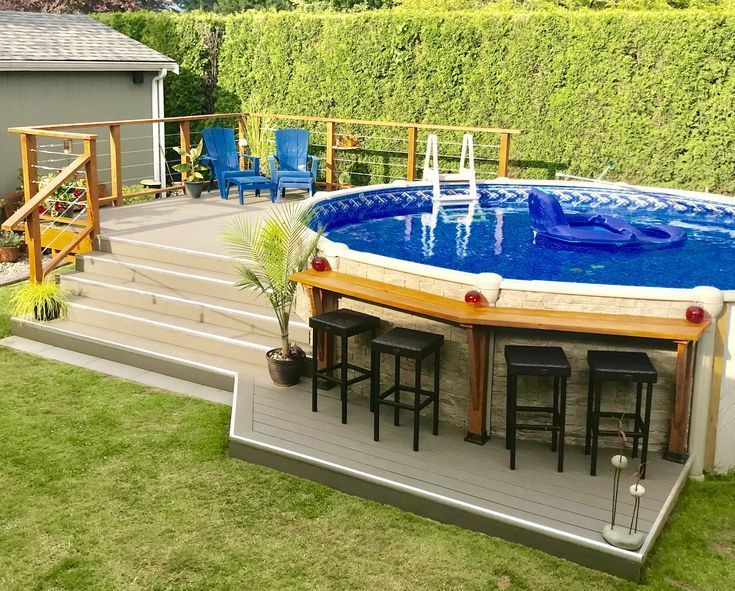 an above ground pool surrounded by lawn chairs and bar stools in the middle of a backyard