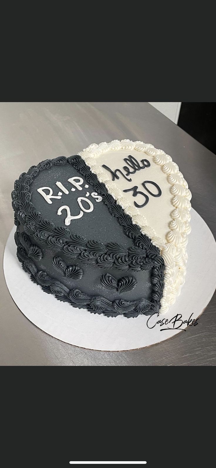 two heart shaped cakes sitting on top of a white cake plate with black and white frosting