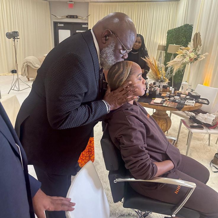 a woman is getting her hair cut by an older man in a suit and tie