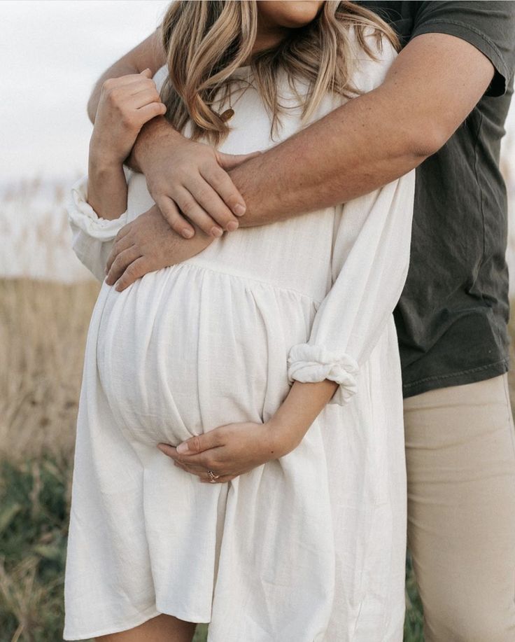 a pregnant woman is holding her husband's belly