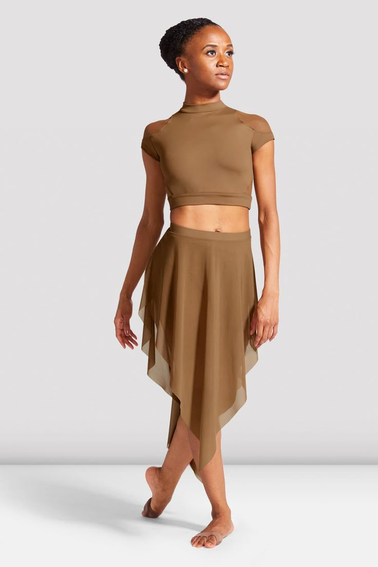 a woman in a tan top and brown skirt