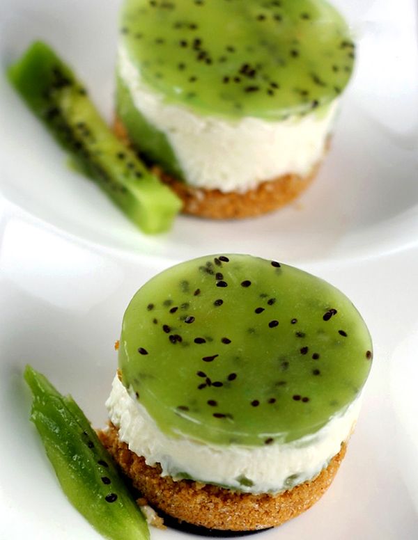 three small desserts with green and white frosting on them, one has a cucumber in the middle