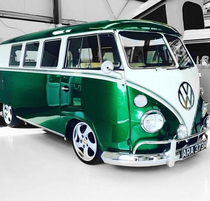 a green and white vw bus parked in a garage