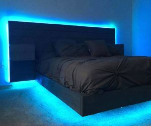 a bed with blue lights on the side and a black headboard in the middle