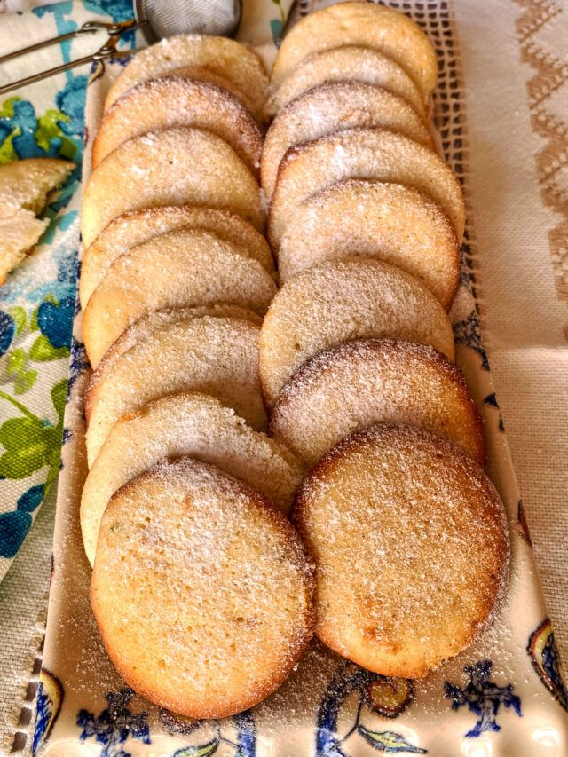 a bunch of cookies that are on a plate next to an orange and some spoons