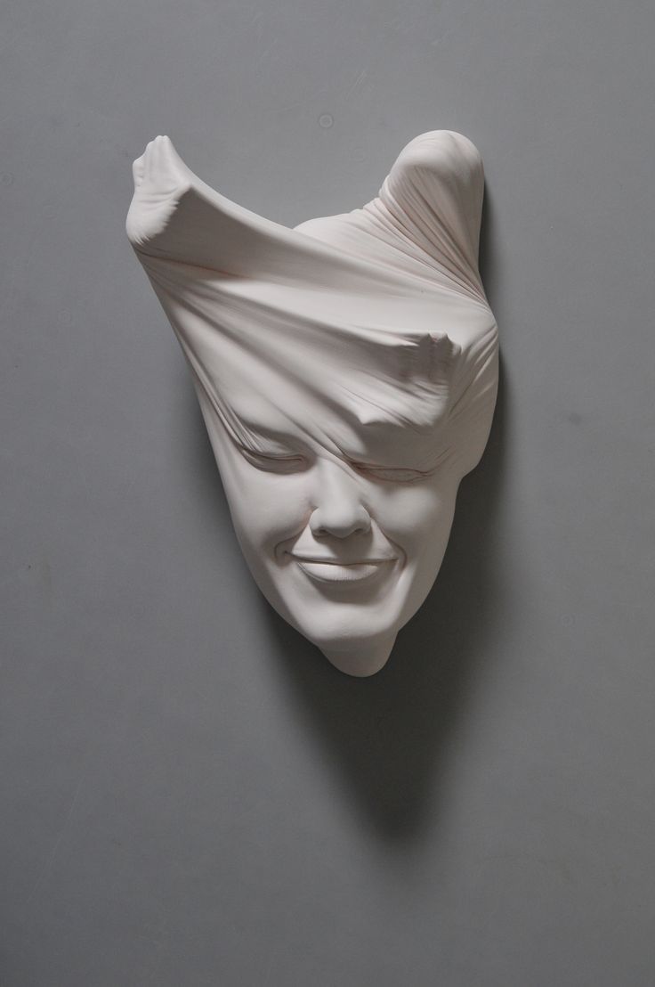 a sculpture of a woman's face on a gray background