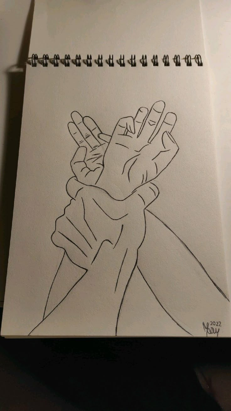 a drawing of two hands holding each other on top of a piece of white paper