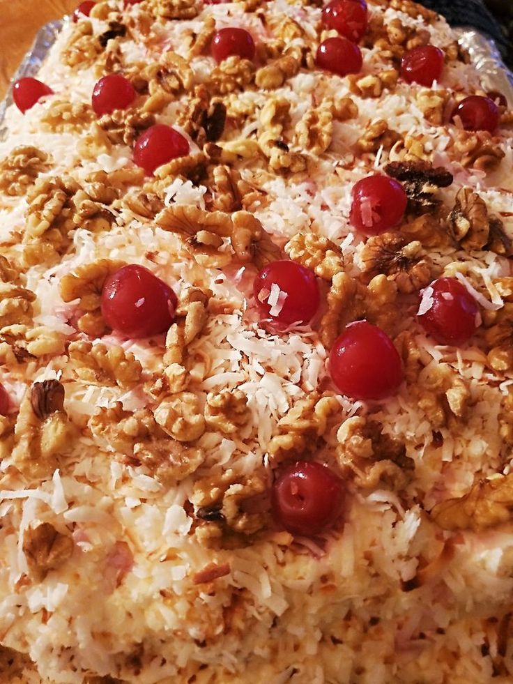 a pizza topped with cherries and nuts on top of a table