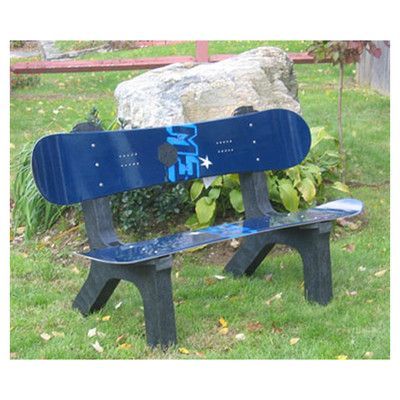 a blue snowboard sitting on top of a wooden bench in the grass next to a rock