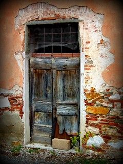 an old wooden door in front of a brick wall