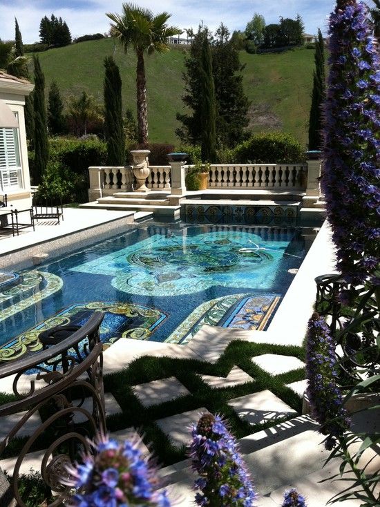 an outdoor swimming pool surrounded by purple flowers