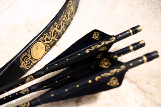 Black Bow and Arrows with Elaborate Gold Design Arrow And Bow Aesthetic, Pretty Bow And Arrow Aesthetic, Pretty Bow And Arrow, Gold Bow And Arrow, Archer Aesthetic, Archery Aesthetic, Pretty Knives, Custom Bows, Bow And Arrow