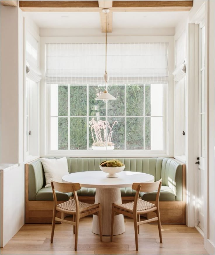 a dining room table with chairs and a bench in front of a window that is open to the outside