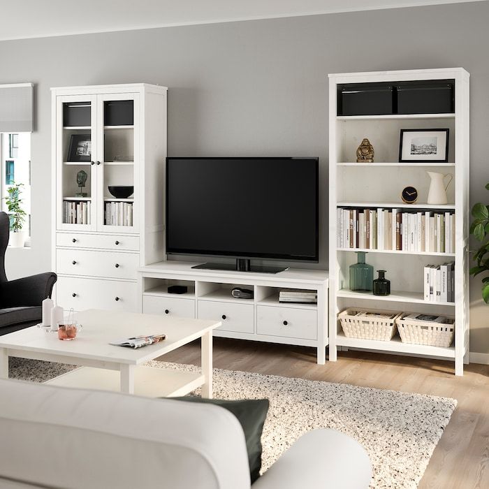 a living room filled with furniture and a flat screen tv on top of a white book shelf