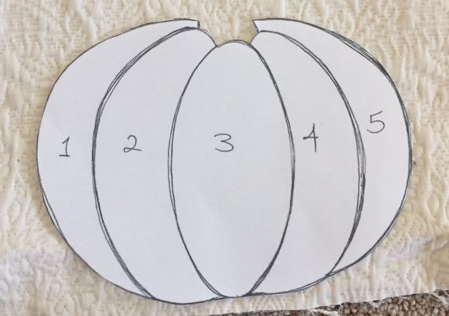 three white pumpkins cut out on top of a piece of paper with numbers in the middle