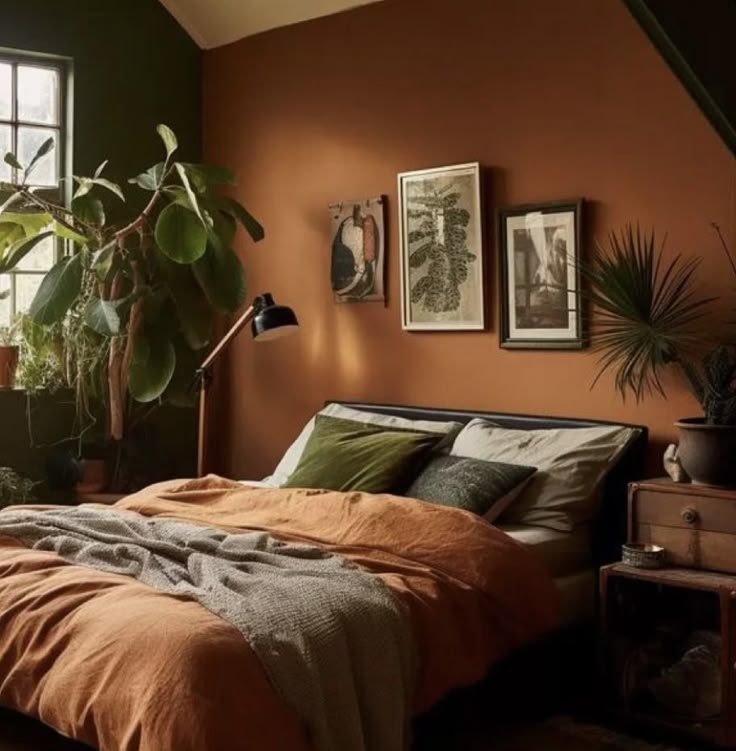 a bedroom with orange walls and lots of plants