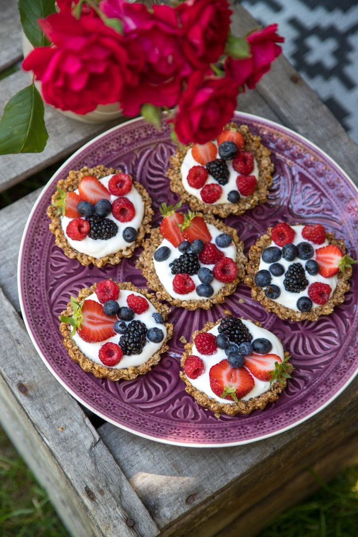 fruit tarts are arranged on a purple plate