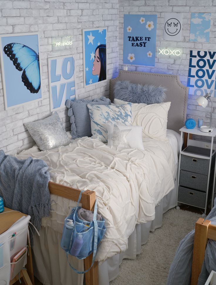 a bedroom with white brick walls and blue accessories on the bed, along with posters