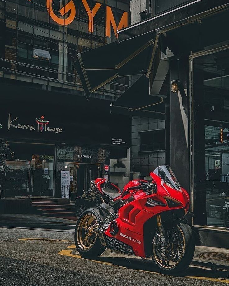 a red motorcycle parked in front of a building