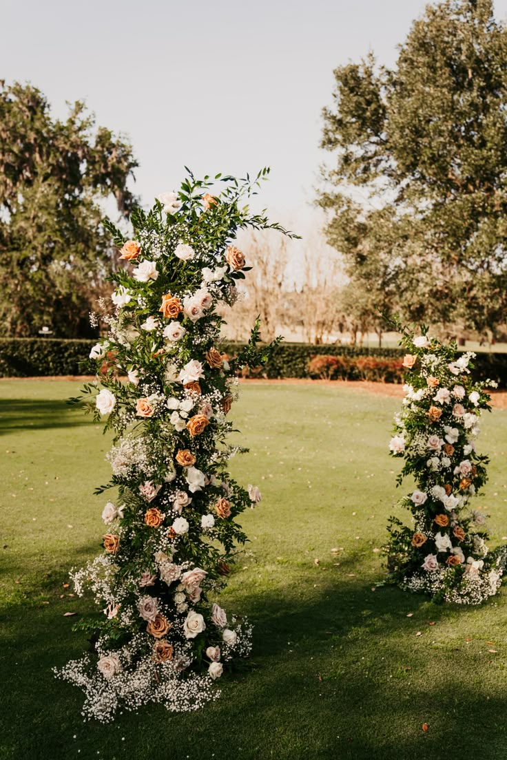 two tall floral arrangements in the middle of a field