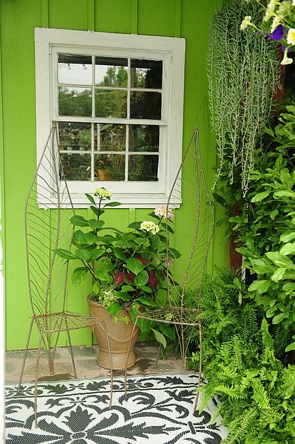 a potted plant sitting next to a window on a tiled floor in front of a green wall