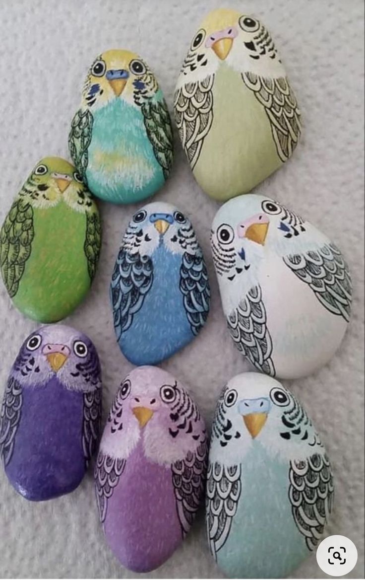 six painted rocks with different colored birds on them