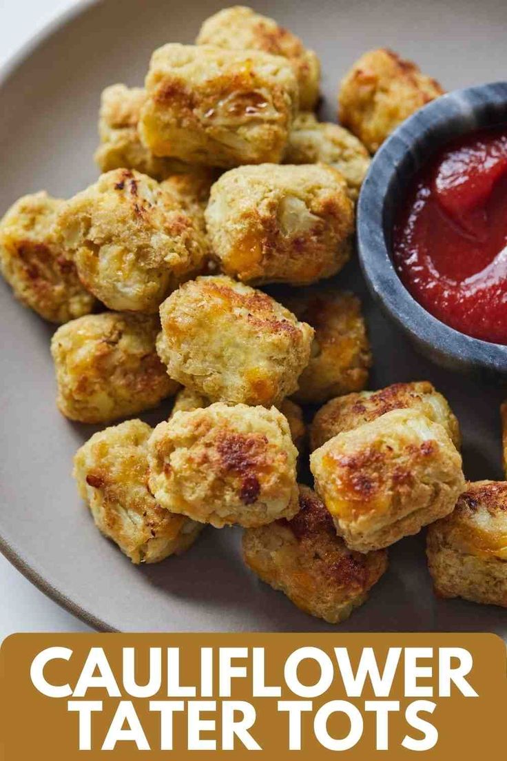 cauliflower tater tots on a plate with ketchup and sauce