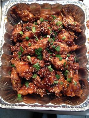 chicken wings covered in sesame seeds and garnished with green onions, cilantro