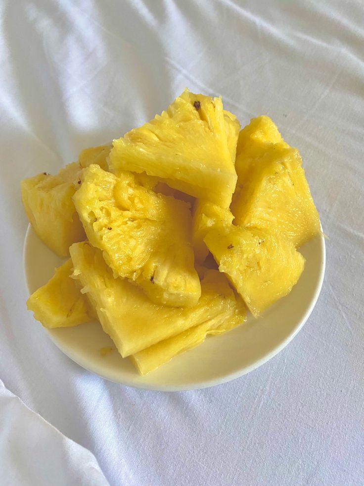 a white plate topped with sliced pineapples on top of a white table cloth