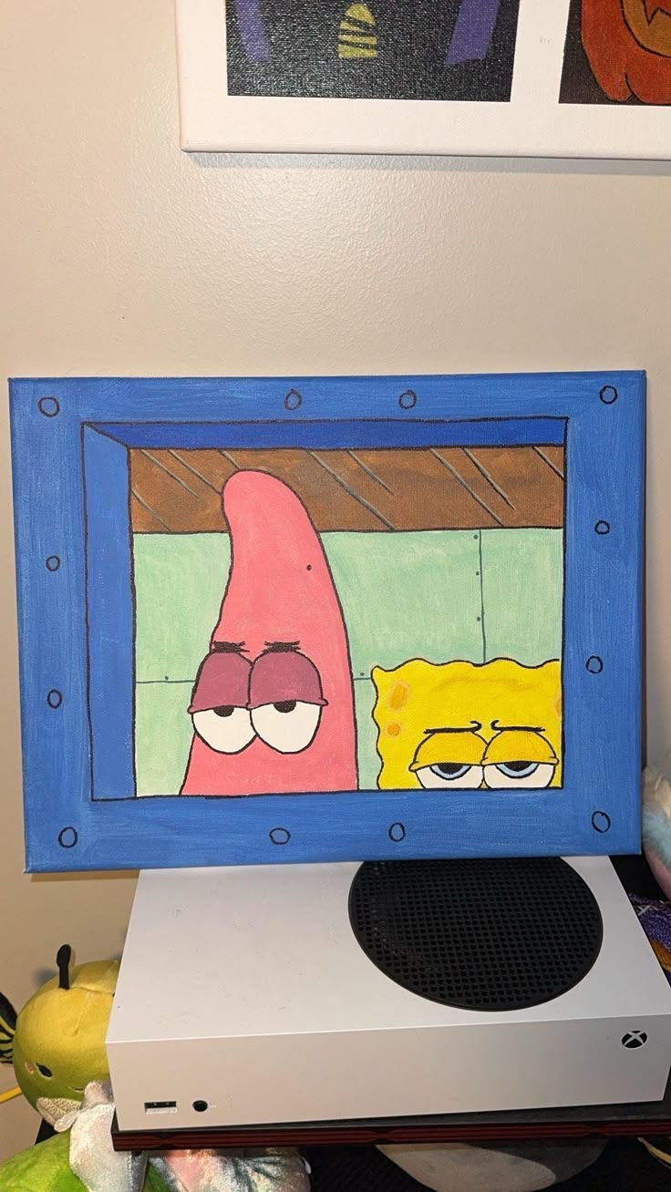 an art project is displayed in front of a laptop computer with the image of spongebob and patrick on it