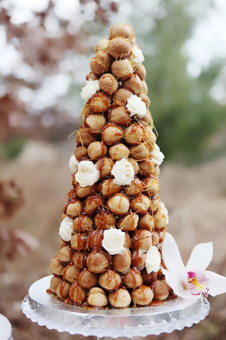 there is a cake made to look like a pine cone with white flowers on top