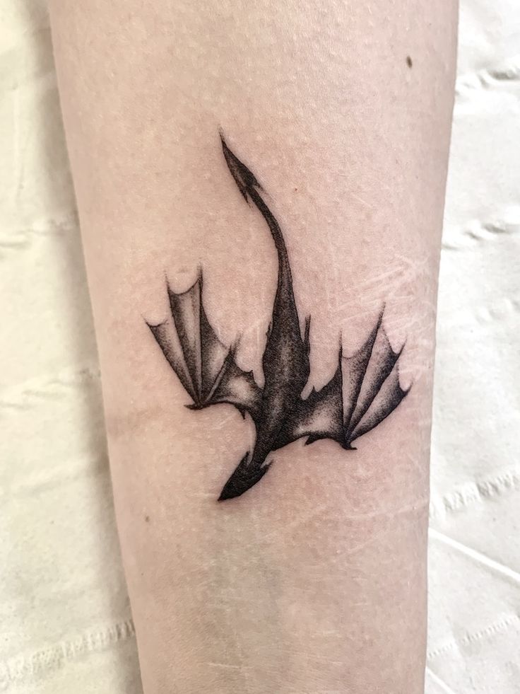 a black and white photo of a tattoo design on the leg with an origami bird