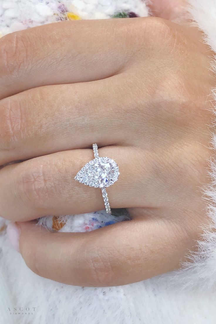 a woman's hand with a diamond ring on it