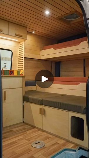 the inside of a small camper with bunk beds and cupboards on each side