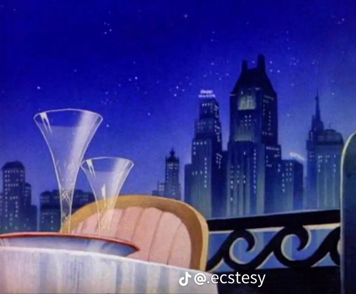 two wine glasses sitting on top of a table in front of a cityscape