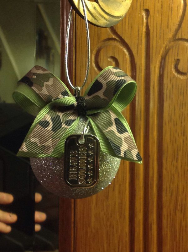 a close up of a cell phone hanging from a door handle with a bow on it