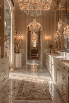 an elegant bathroom with chandeliers and marble floors, along with large mirrors on the walls